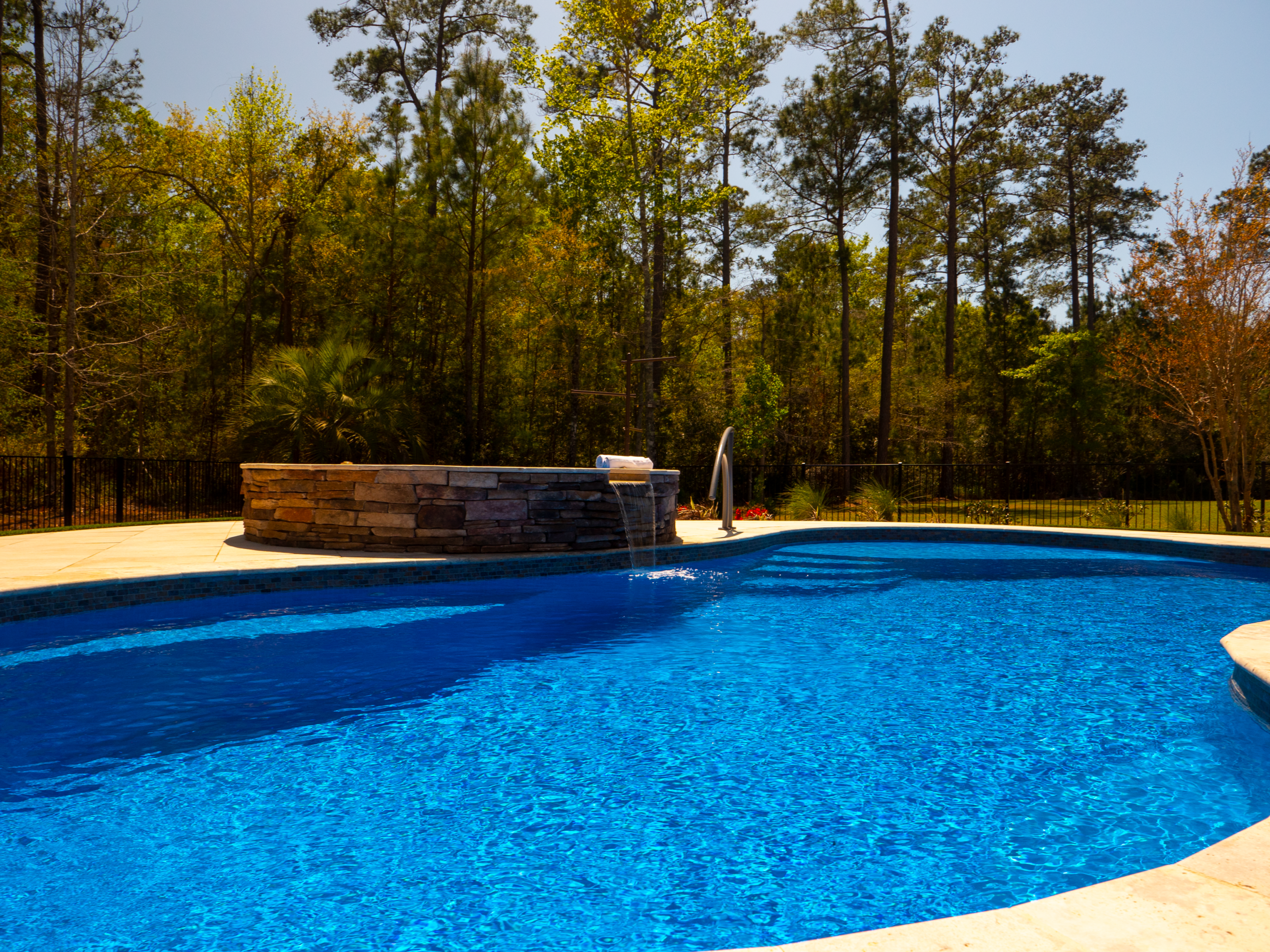 River Pools I30 + RS08 with spillway in Maya Shimmer with natural stone patio and coping 17