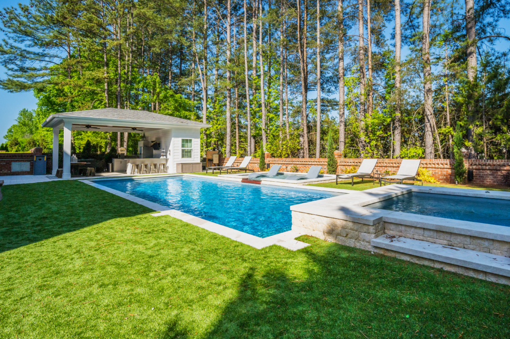River Pools R40 + SS08 with spillway + TL15 with spillway in Granite Gray with bubblers, turf patio and natural stone coping 11