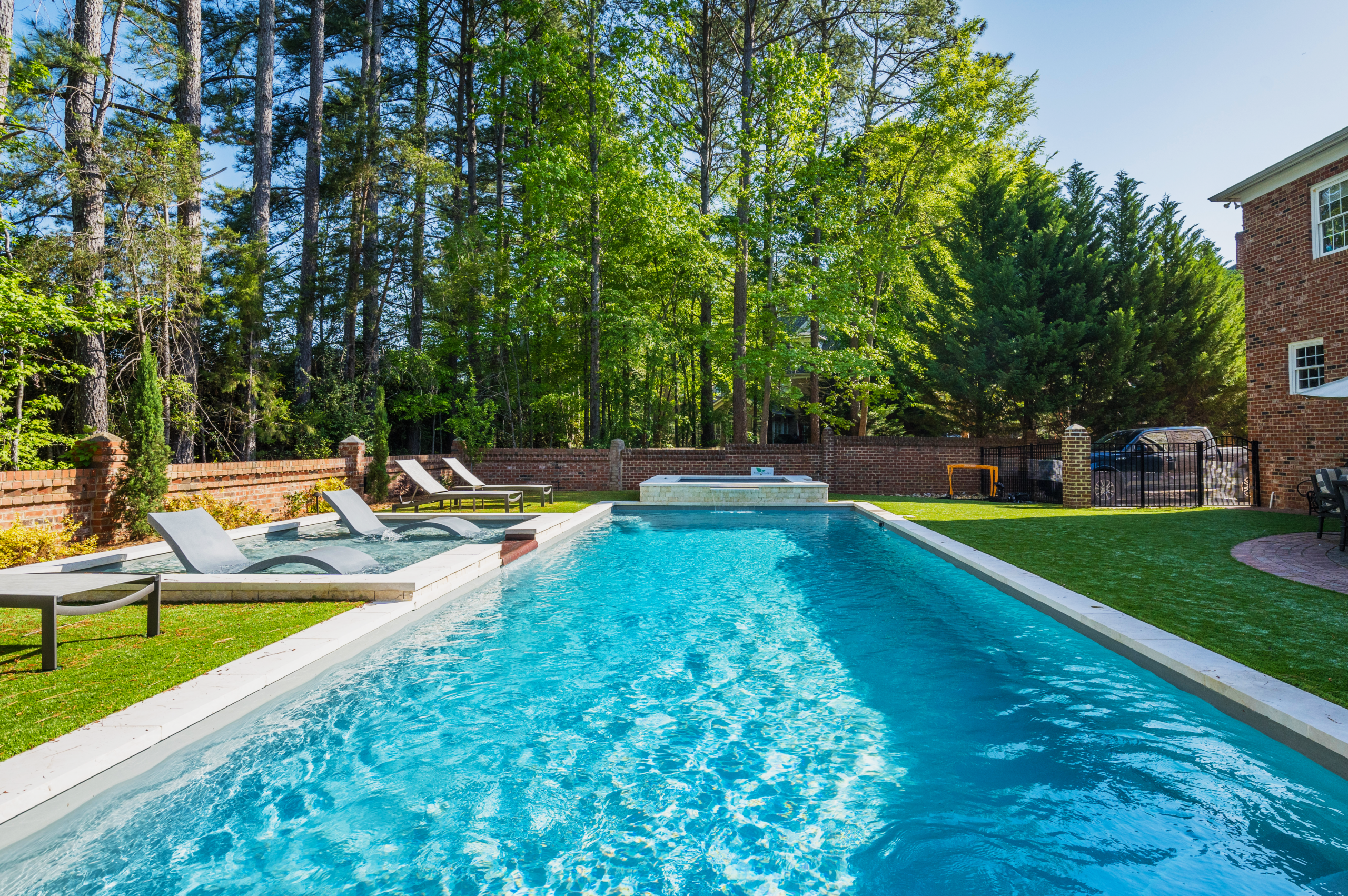 River Pools R40 + SS08 with spillway + TL15 with spillway in Granite Gray with bubblers, turf patio and natural stone coping 4